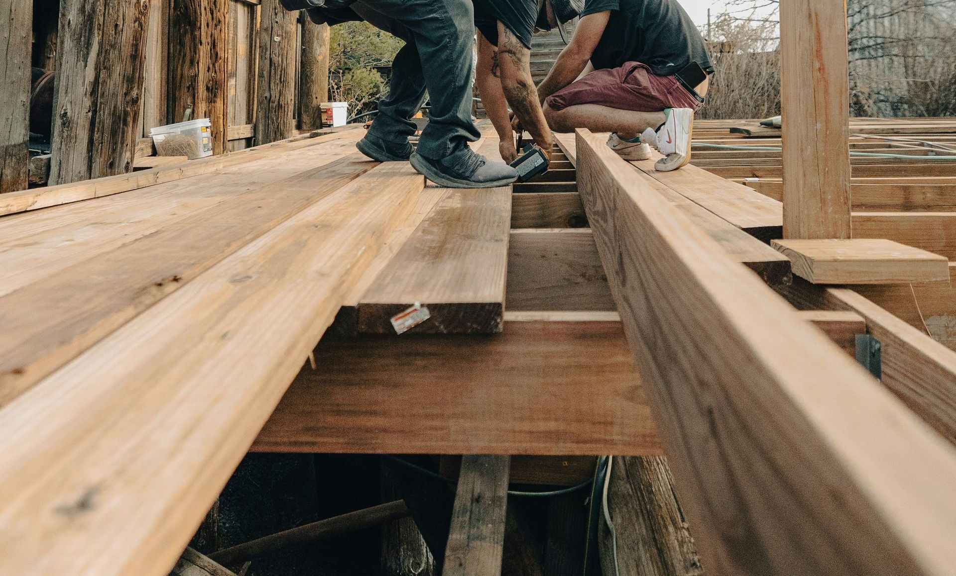 Two men working on a wooden deck construction